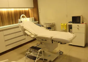Sala de atendimento da clínica com maca e ambiente acolhedor